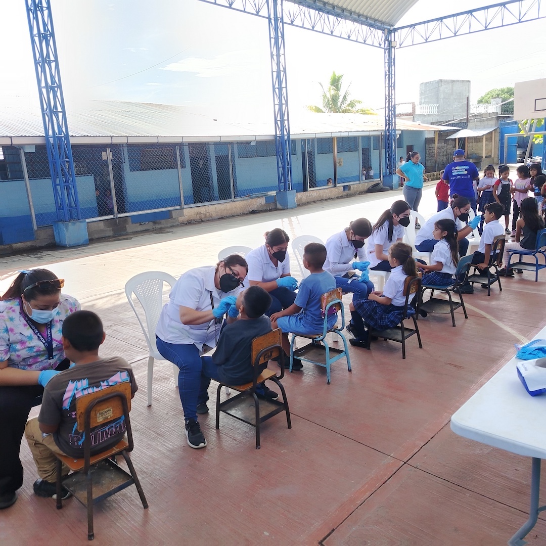 children receiving fluoride schoolroom with dental stations, patients and providers